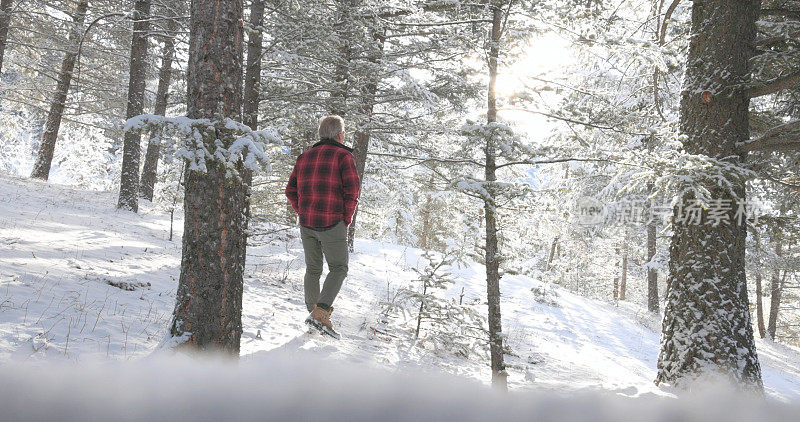 成熟的男人走在雪山小路上