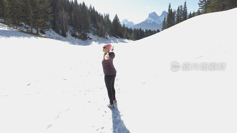 成熟的夫妇走在雪山小路上