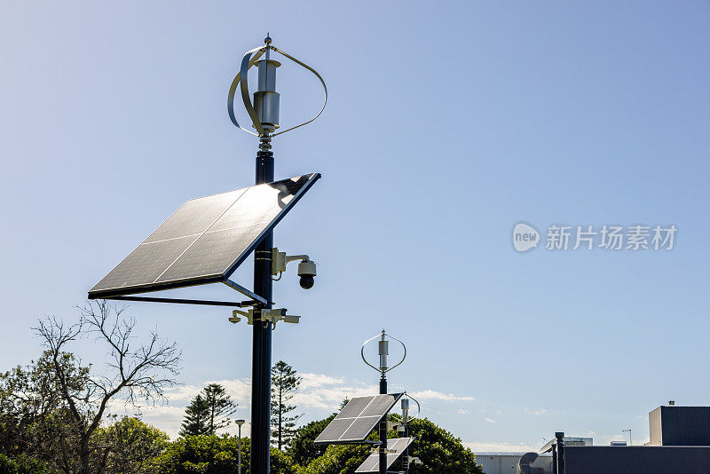 小型太阳能电池板与风力涡轮机，蓝天背景与复制空间