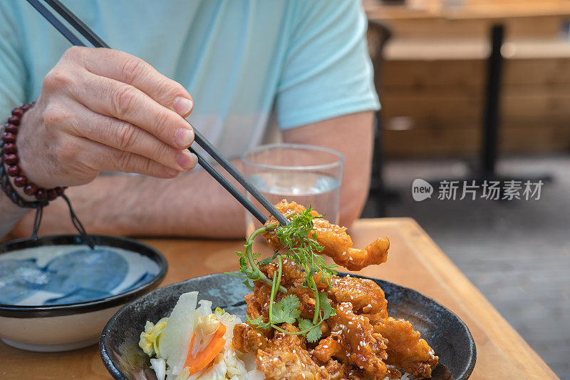 男子用筷子吃素食越南蘑菇天妇罗，户外露台