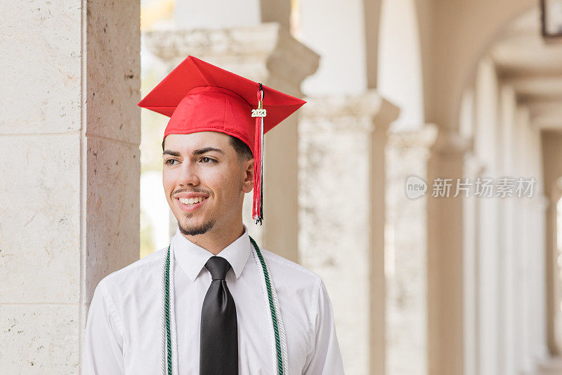 一位18岁的古巴裔美国人，棕色头发和棕色眼睛，穿着白色礼服衬衫，黑色领带和黑色裤子，戴着红色毕业帽和三个荣誉流苏，在佛罗里达州棕榈滩，看起来很聪明