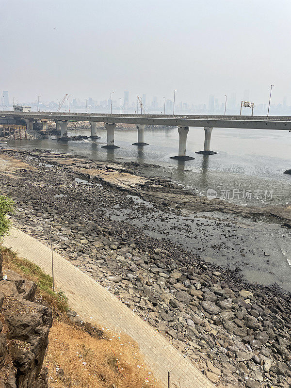 印度孟买班德拉-沃利海路(拉吉夫甘地海路)的图片，混凝土、斜拉桥、岩石海岸线、海水、八车道高架桥、柱子、烟雾