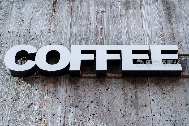 招牌是一家咖啡餐厅，咖啡厅的墙上挂着字，白色的印刷字母，立体的广告符号。