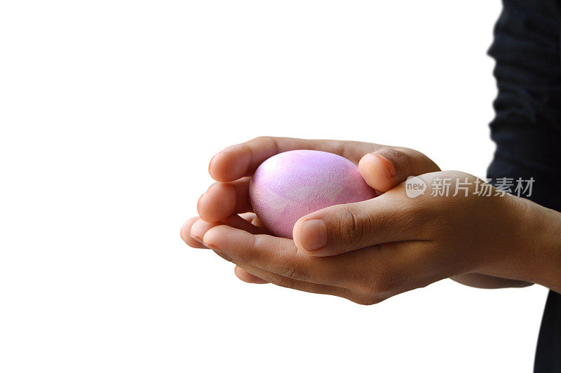 剪出一个单一的粉彩复活节彩蛋握在双手，双手抱着它的关心和感情的爱孤立在白色透明的背景复活节节日庆祝活动与充足的复制空间