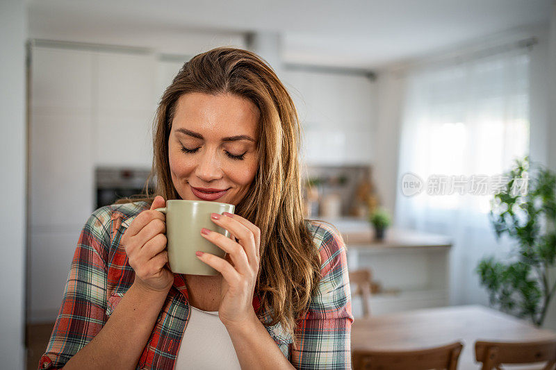 早晨舒缓的节奏——一位年轻女子在厨房里享受着早晨的咖啡