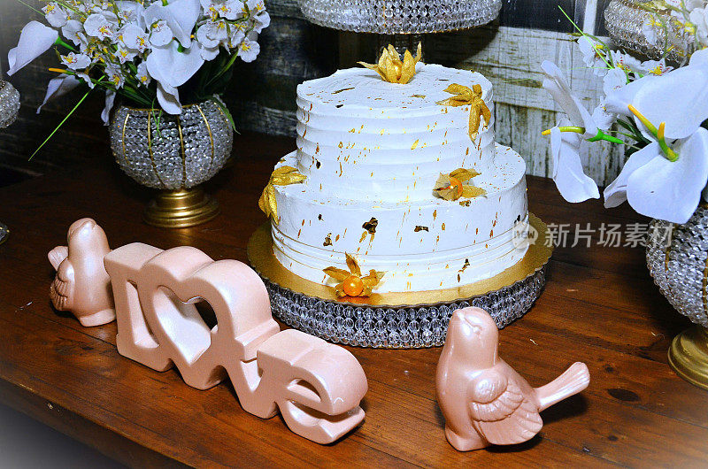 美丽的“爱”的标志和白色蛋糕装饰的物理果金婚派对