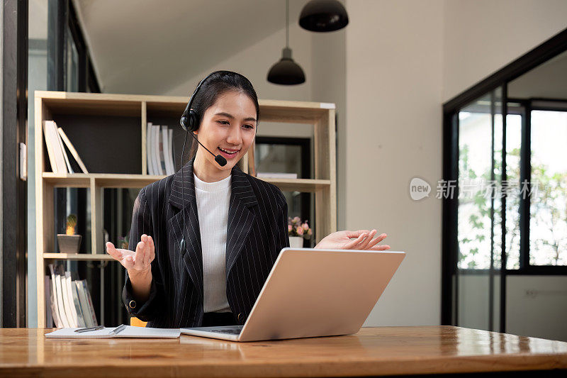 客服中心友好的亚洲女性负责客户服务，技术支持和建议，与客服中心的员工接线员联系和沟通