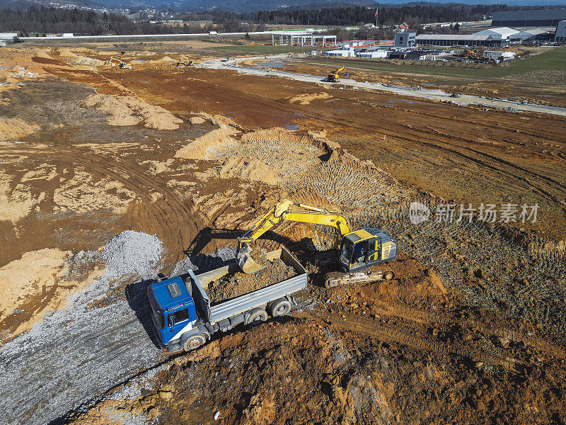 乡村道路施工——挖土机挖出泥土，装上卡车