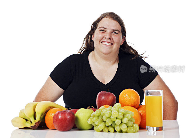 超重的年轻女子愉快地考虑传播健康的食物