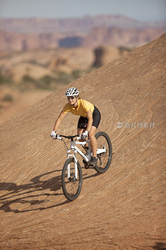 女自行车手骑下坡山地自行车在摩押，犹他州