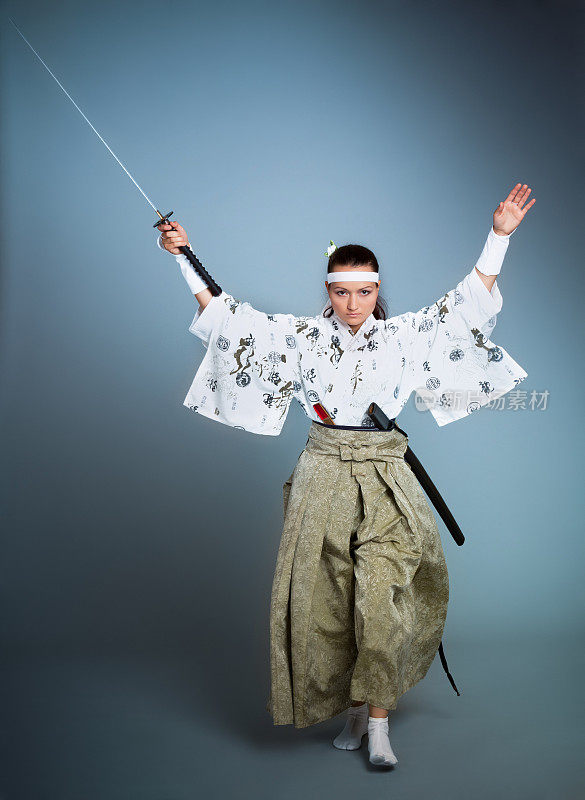 好斗的年轻女人穿着日本衣服和武士刀移动