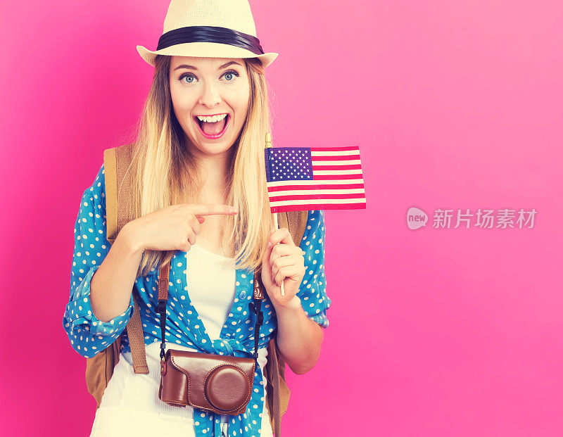 快乐的年轻女旅行者举着美国国旗