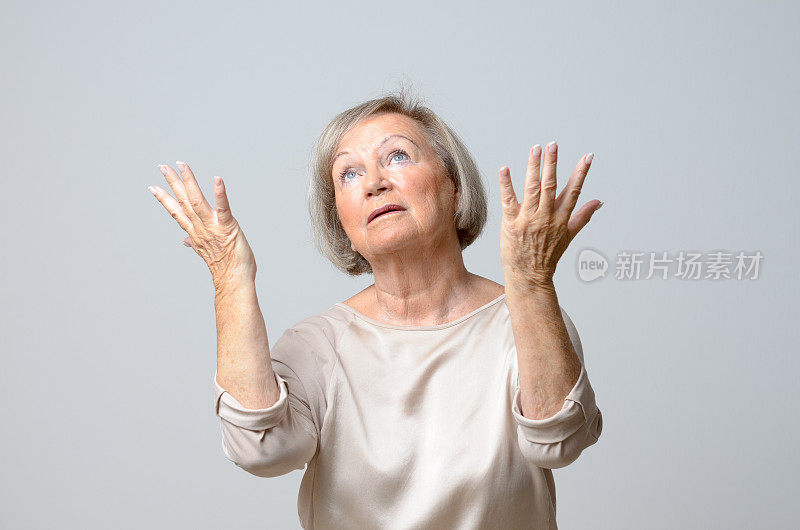 一位年长的女士双手举向天空