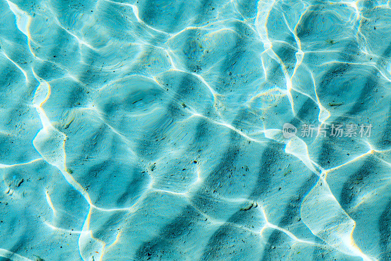 蓝色清澈透明的水背景与沙子