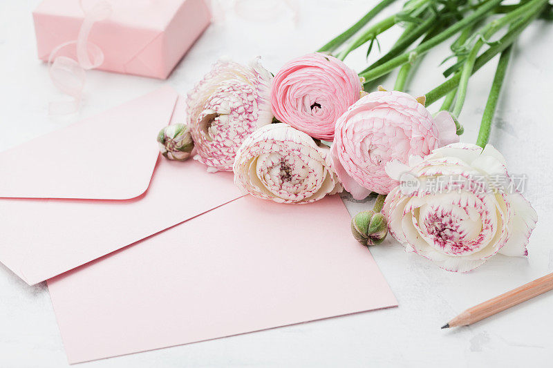 信封或信件，纸卡，礼物和粉红色的毛茛花。问候母亲或妇女节。