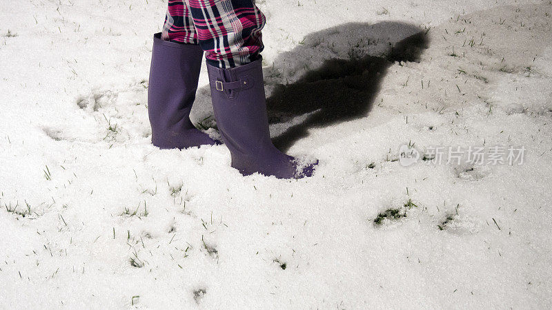 穿着胶靴在雪地里行走