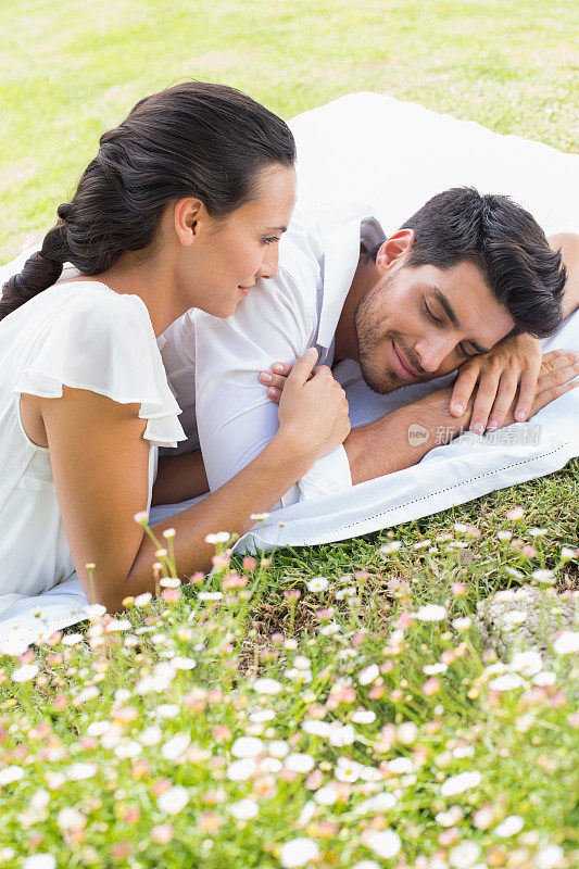 一对幸福的情侣一起躺在草地上