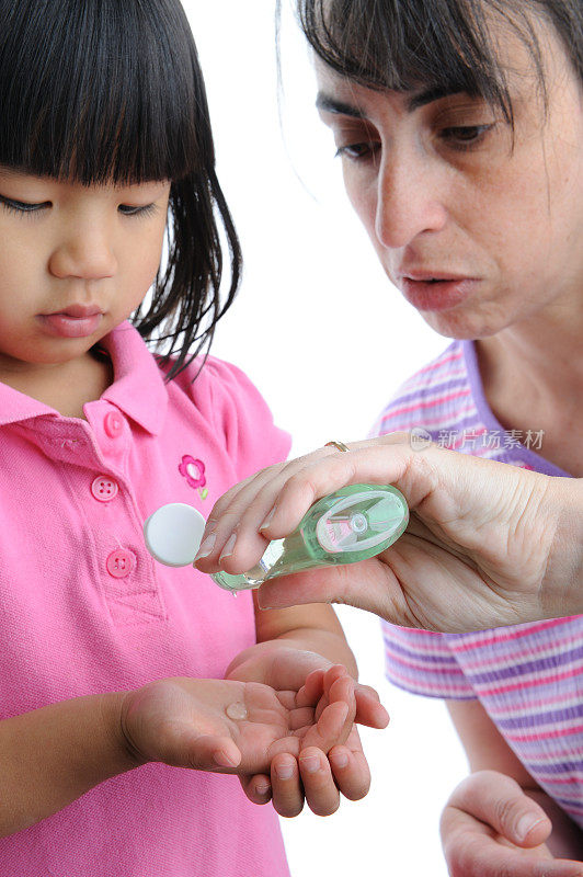 流感预防:妇女给孩子用消毒凝胶
