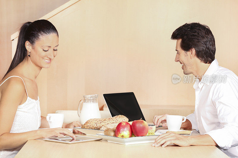 年轻夫妇在他们的早餐搜索互联网