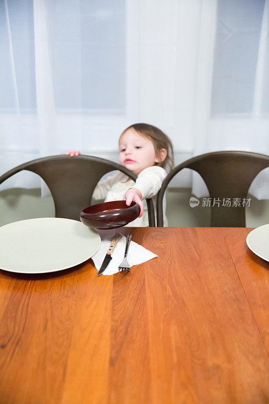 小女孩正在帮忙摆桌子准备吃饭