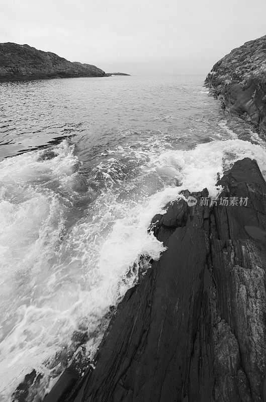 在有雾的天气里，海浪拍打着多岩石的海岸