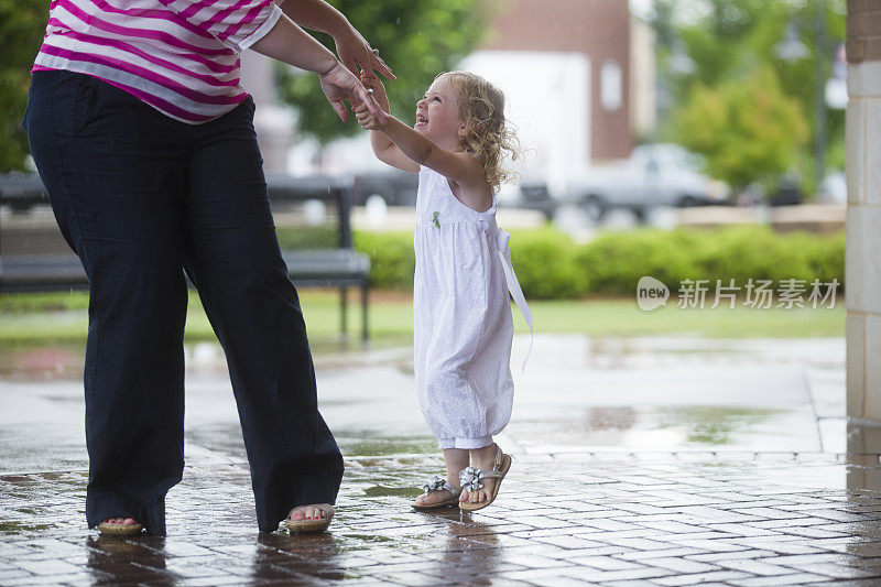 母亲和女儿在雨中跳舞