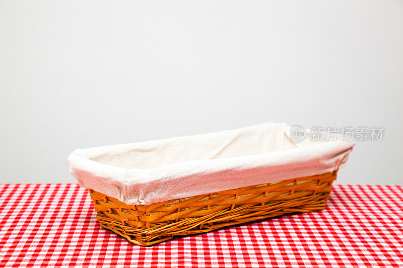 在传统的红色格子布桌布上放空面包篮