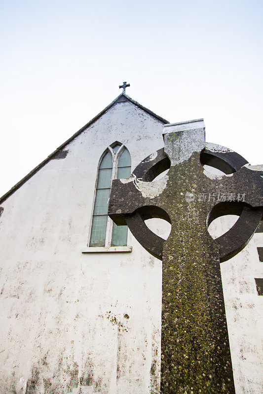 教堂与凯尔特十字墓碑在前景，爱尔兰
