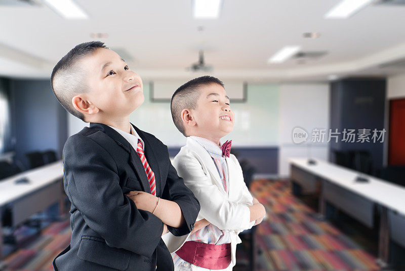 快乐微笑的小商务男孩在会议厅的背景