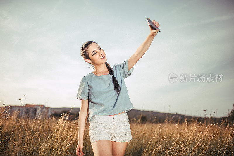 年轻漂亮的女人戴着耳机自拍