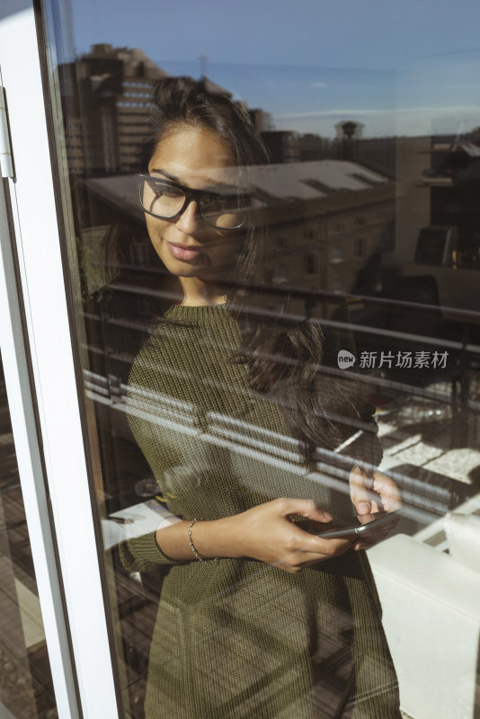 年轻漂亮的女人在用她的智能手机