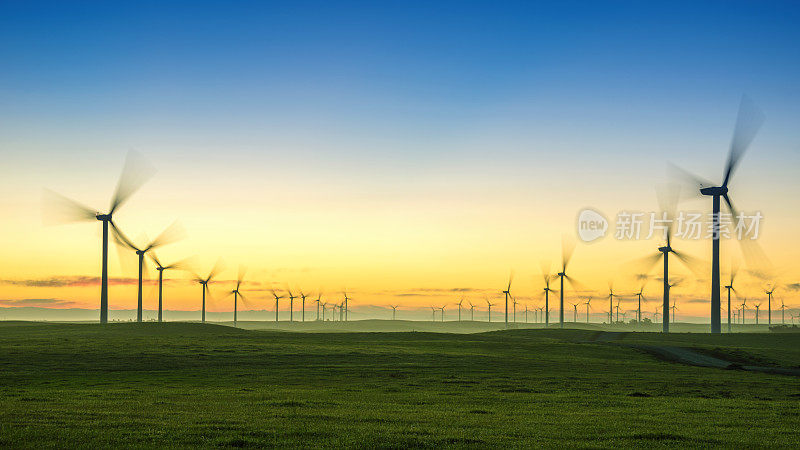 日出与风力涡轮机和绿草
