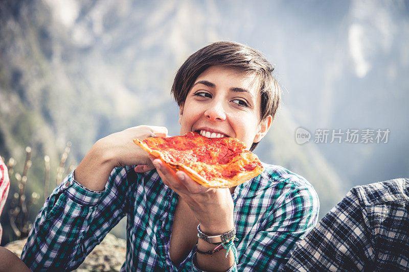 一个在山上吃披萨小吃的女人