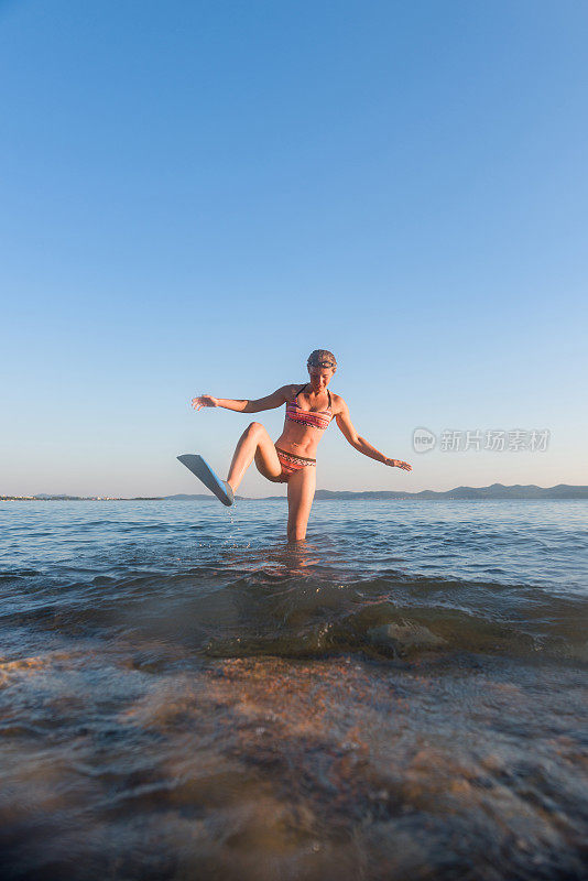 在海边带着水肺潜水设备的女人