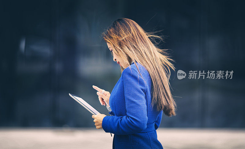 亚洲女商人手持数码平板电脑