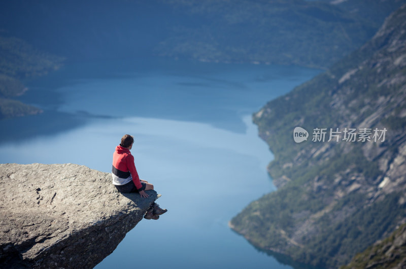 一名男子坐在挪威巨魔之石上