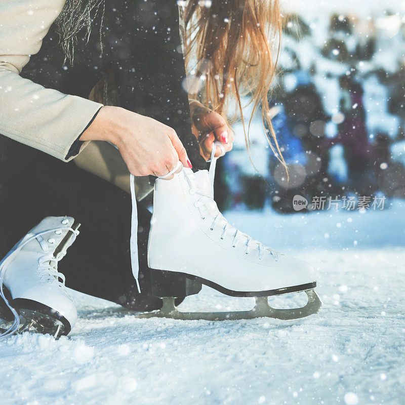 女人系鞋带在冰场的花样滑冰特写
