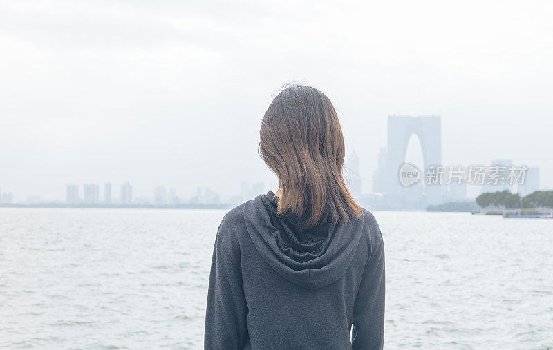 后视图的女人站在湖边看美丽的风景