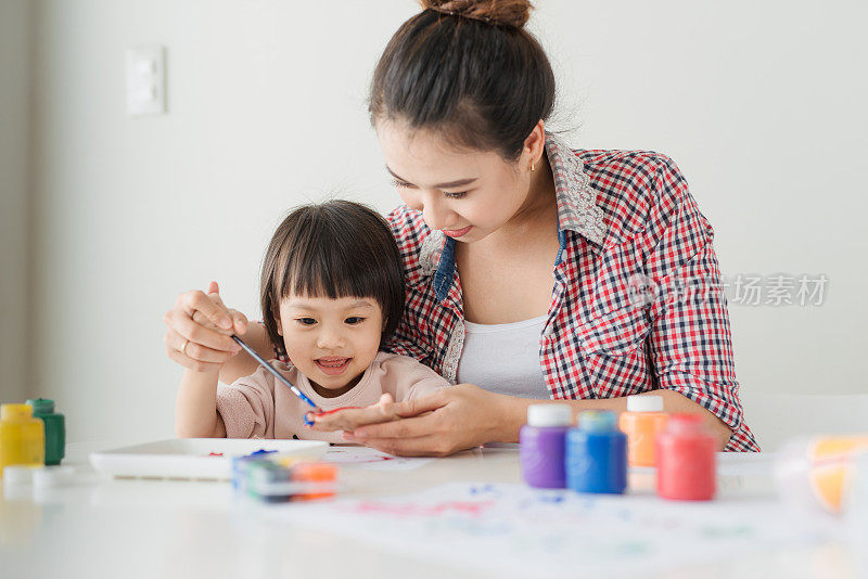 小女孩和她妈妈在家里画画