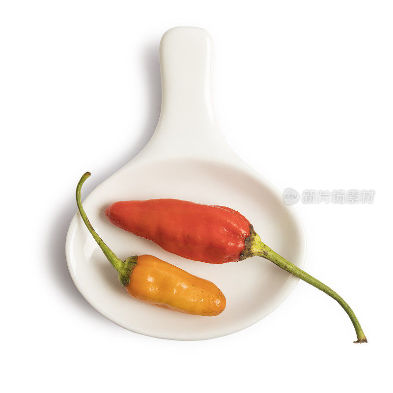 香料和辣椒放在勺子孤立的白色背景