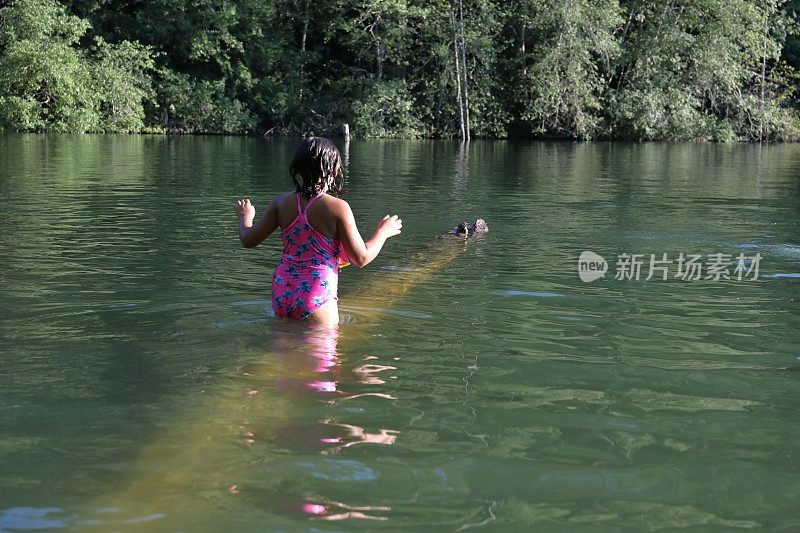 女孩走进淡水湖，在一根圆木上保持平衡