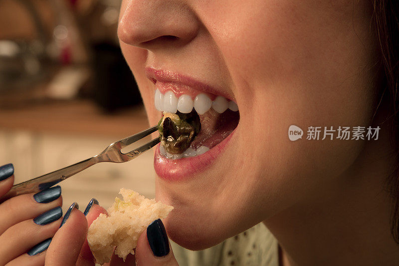 女人吃蜗牛的特写。