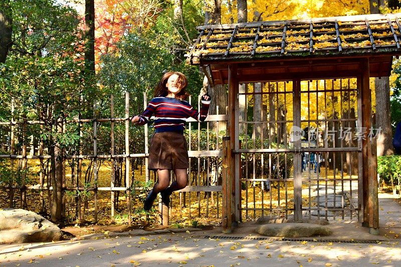 年轻的日本女子在日本东京的御田黑公园跳和打旋