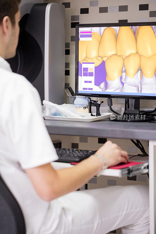 牙科技术员使用电脑操作牙科设备