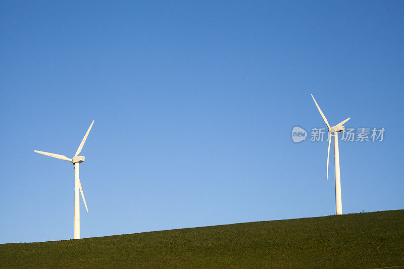 风力发电机，野外斜坡，清澈的蓝天背景。
