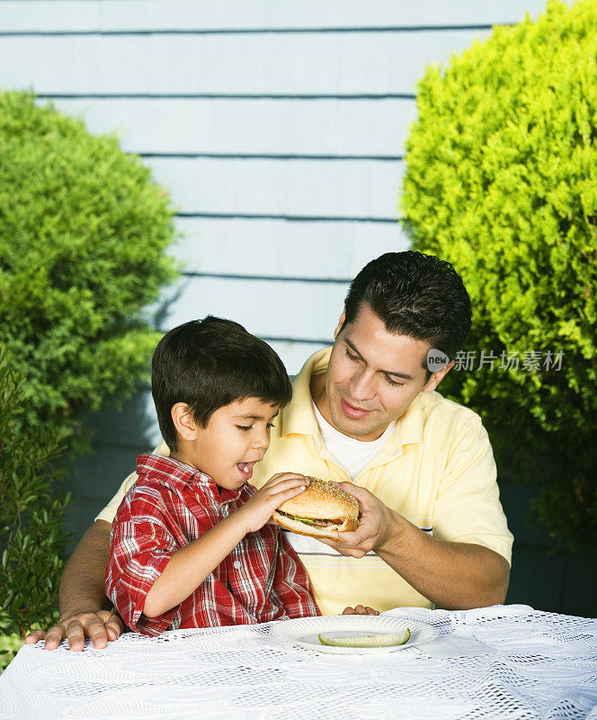 西班牙父亲帮儿子吃汉堡包