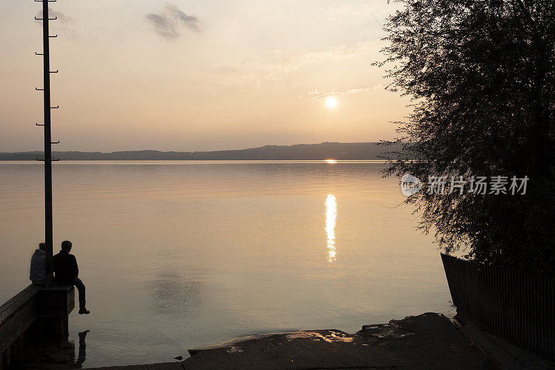 一对夫妇在上巴伐利亚的斯达恩伯格湖欣赏日落
