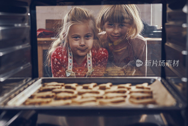 等待圣诞饼干在烤箱里烤的小女孩