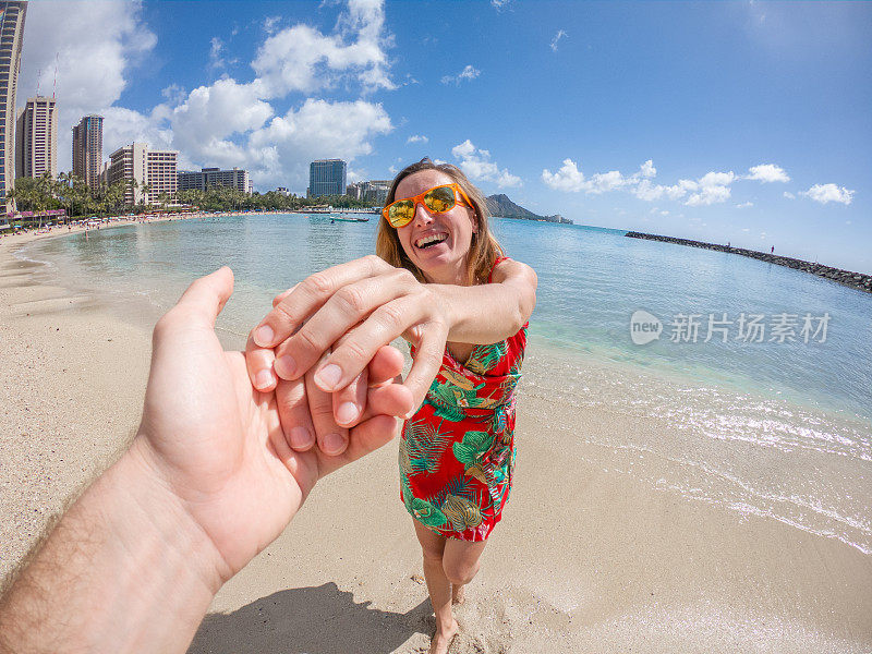 跟我来概念;年轻女子牵着男朋友的手去海滩