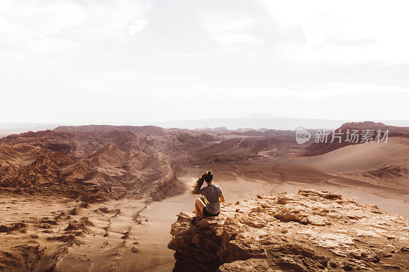 在美丽的阿塔卡马沙漠峡谷里，女人遇见日落